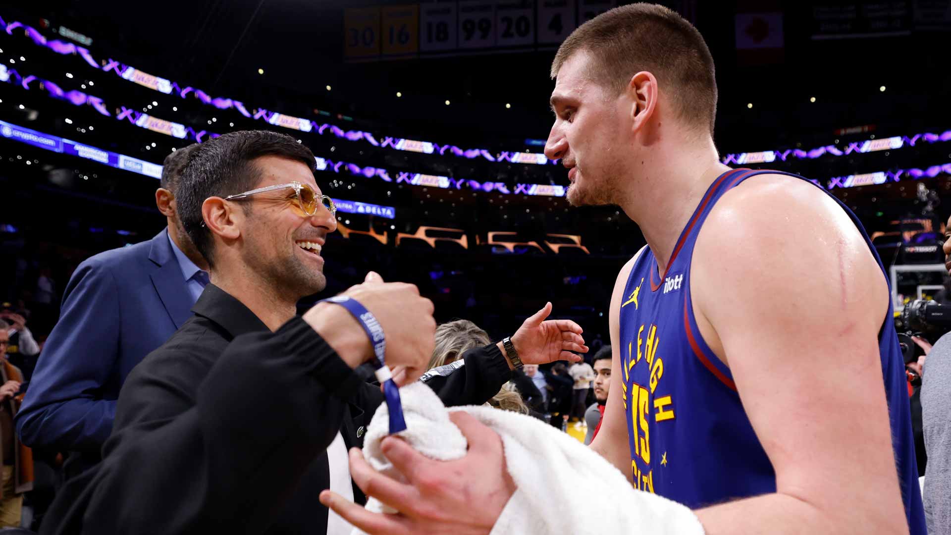 Novak Djokovic and Nikola Jokic speak after the Denver Nuggets' win against the Los Angeles Lakers Saturday in Los Angeles.