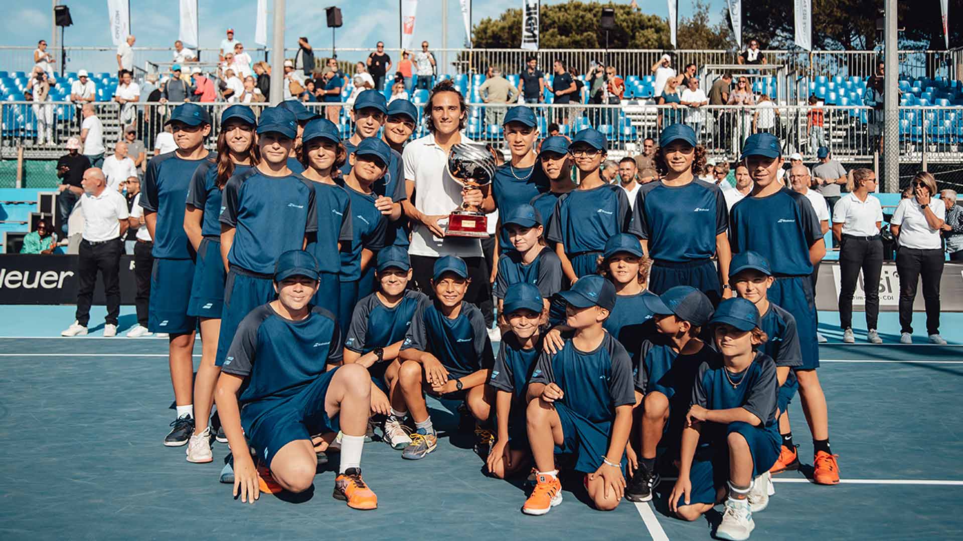 <a href='https://www.atptour.com/en/players/mattia-bellucci/b0gg/overview'>Mattia Bellucci</a> poses with the ballkids at the 2022 Saint-Tropez Challenger.