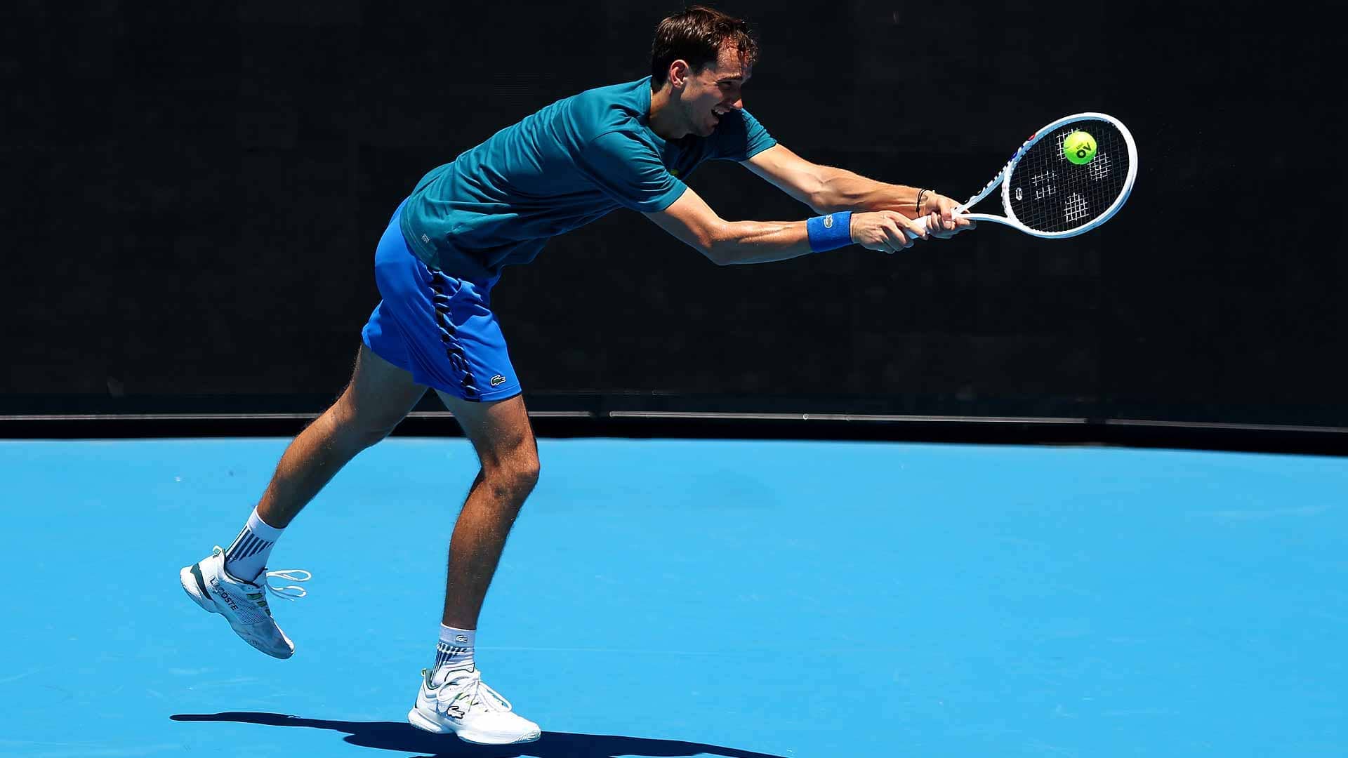 Daniil Medvedev practises with a stencil of his new logo on the strings of his racquet.