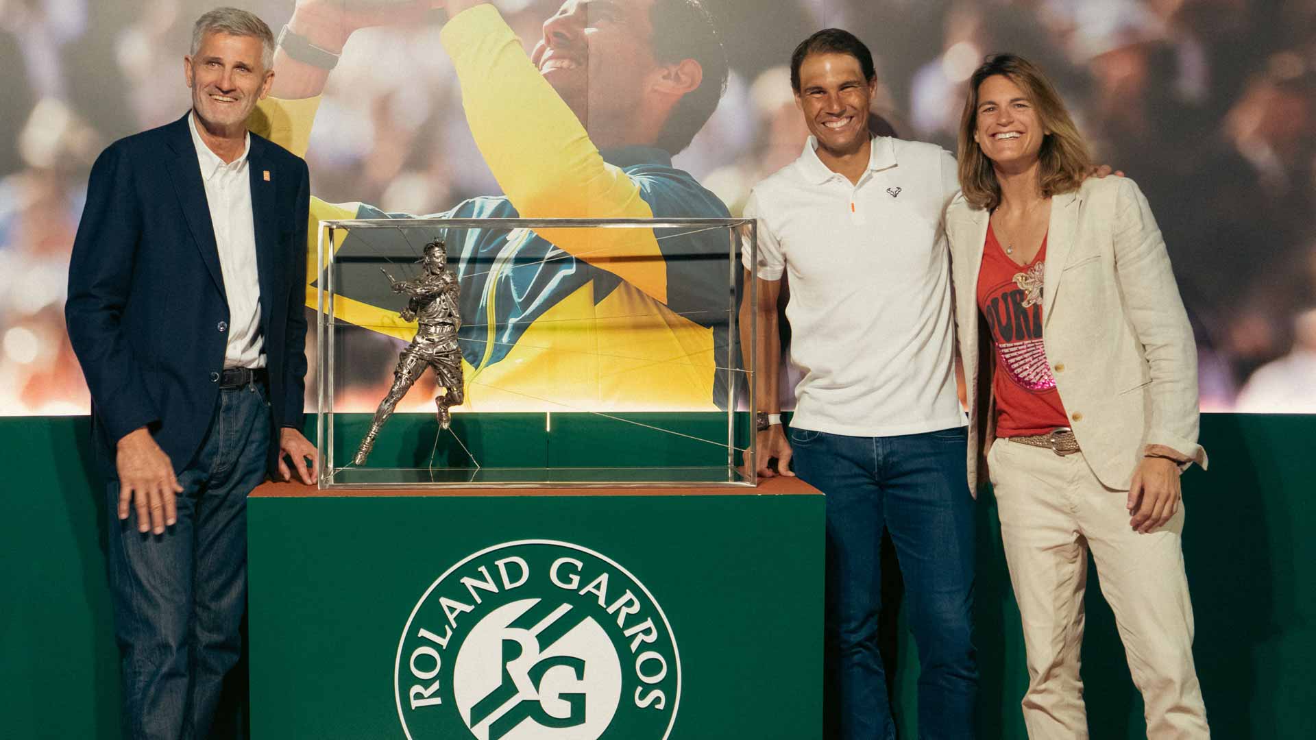 Gilles Moretton (far left), Rafael Nadal, and Amelie Mauresmo pose with a replica sculpture of the Spaniard.