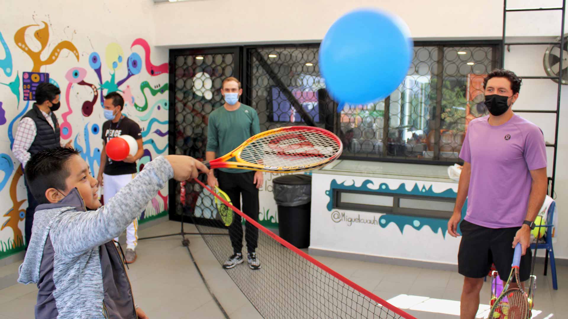 <a href='https://www.atptour.com/en/players/hans-hach-verdugo/h938/overview'>Hans Hach Verdugo</a> and a kid enjoying balloon fun at Antes de Partir A.C.