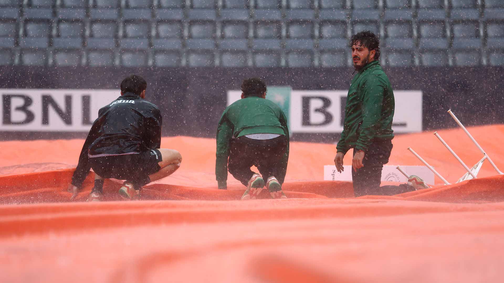 Internazionali BNL d'Italia grounds staff cover the Foro Italico's centre court on Sunday in Rome.