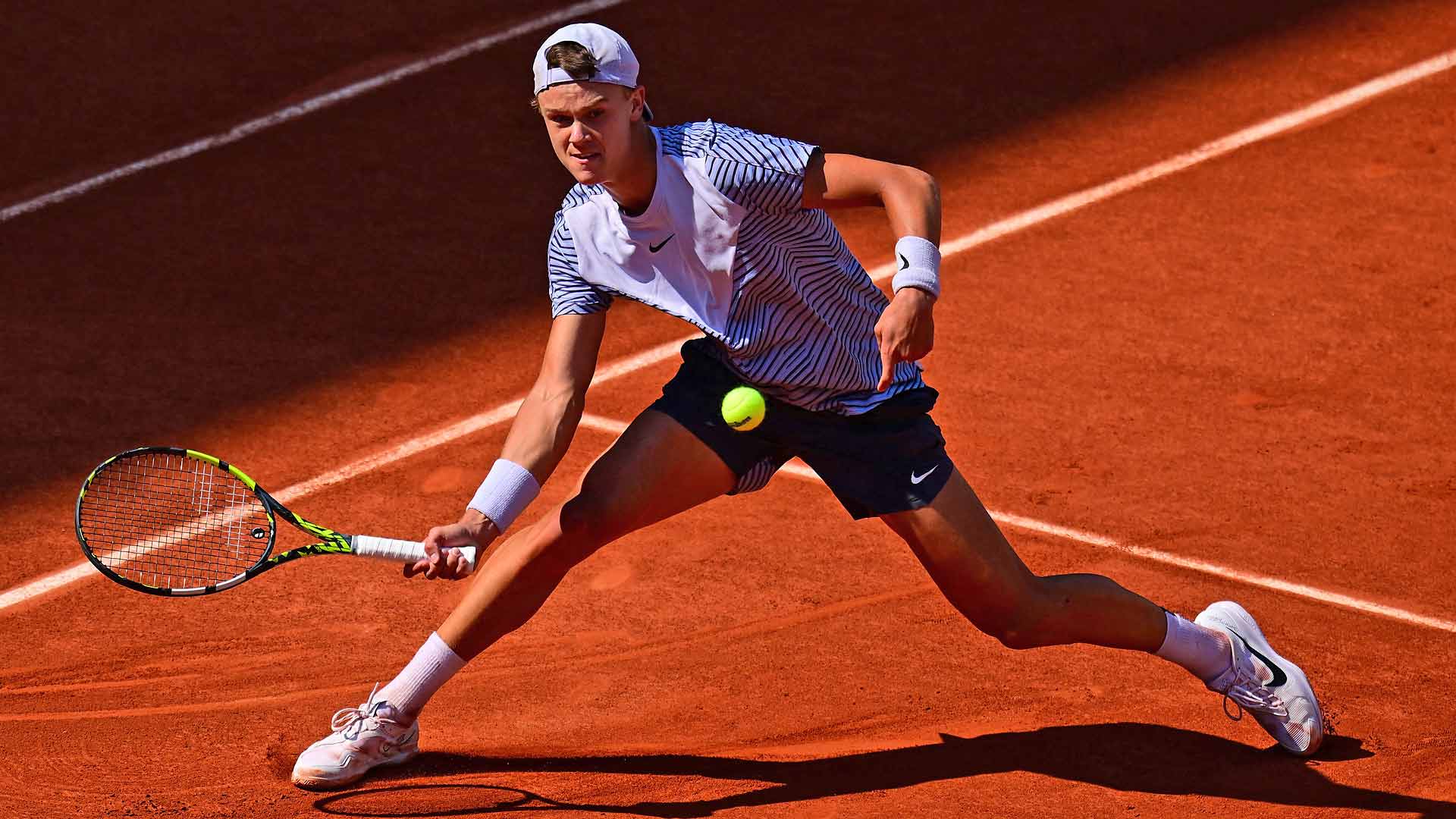 Holger Rune persigue una pelota durante su duelo de cuarta ronda ante Francisco Cerúndolo en Roland Garros 2023.