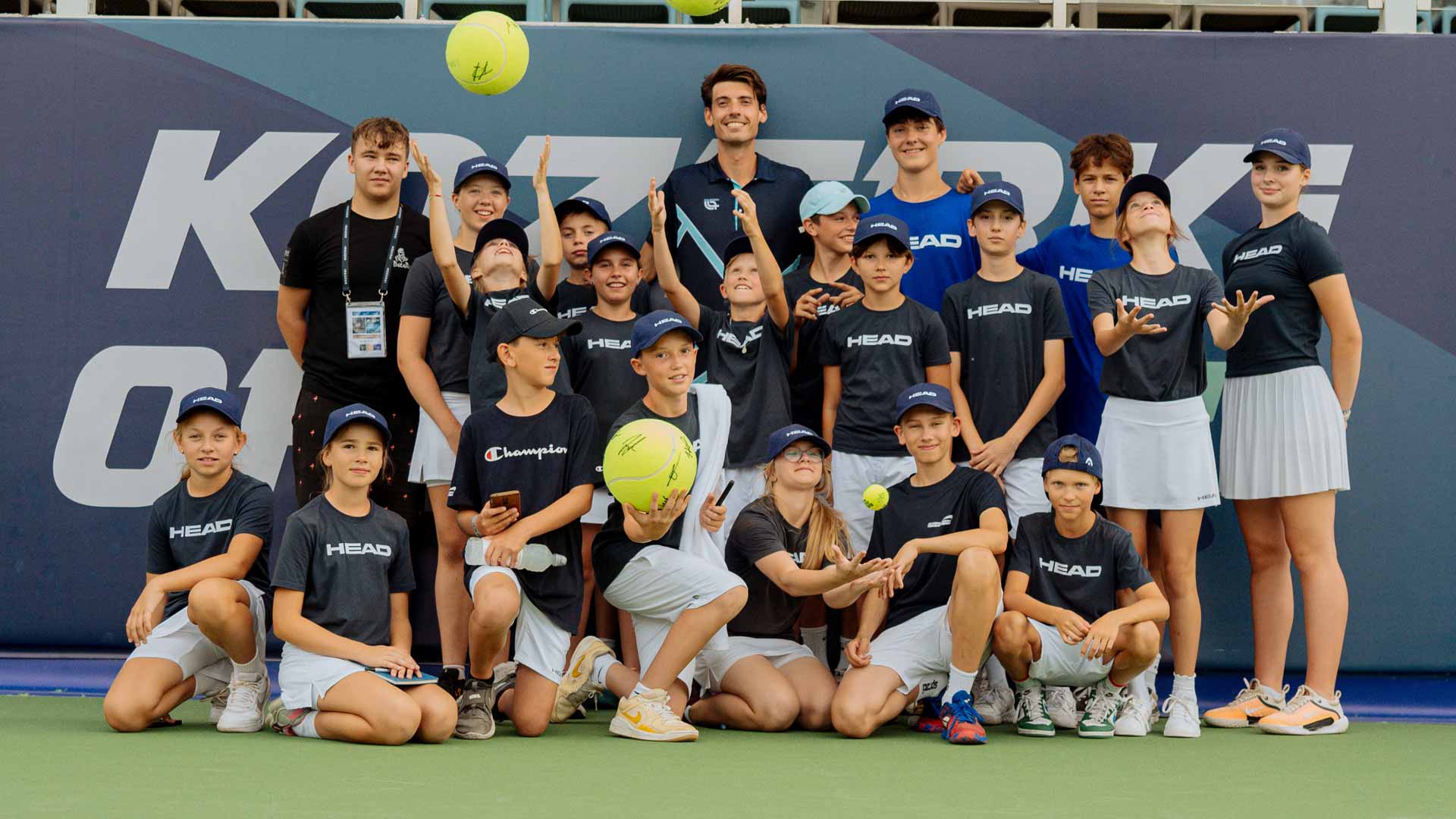 <a href='https://www.atptour.com/en/players/marc-andrea-huesler/hh06/overview'>Marc-Andrea Huesler</a> poses with the Grodzisk Mazowiecki ballkids affter the trophy ceremony.