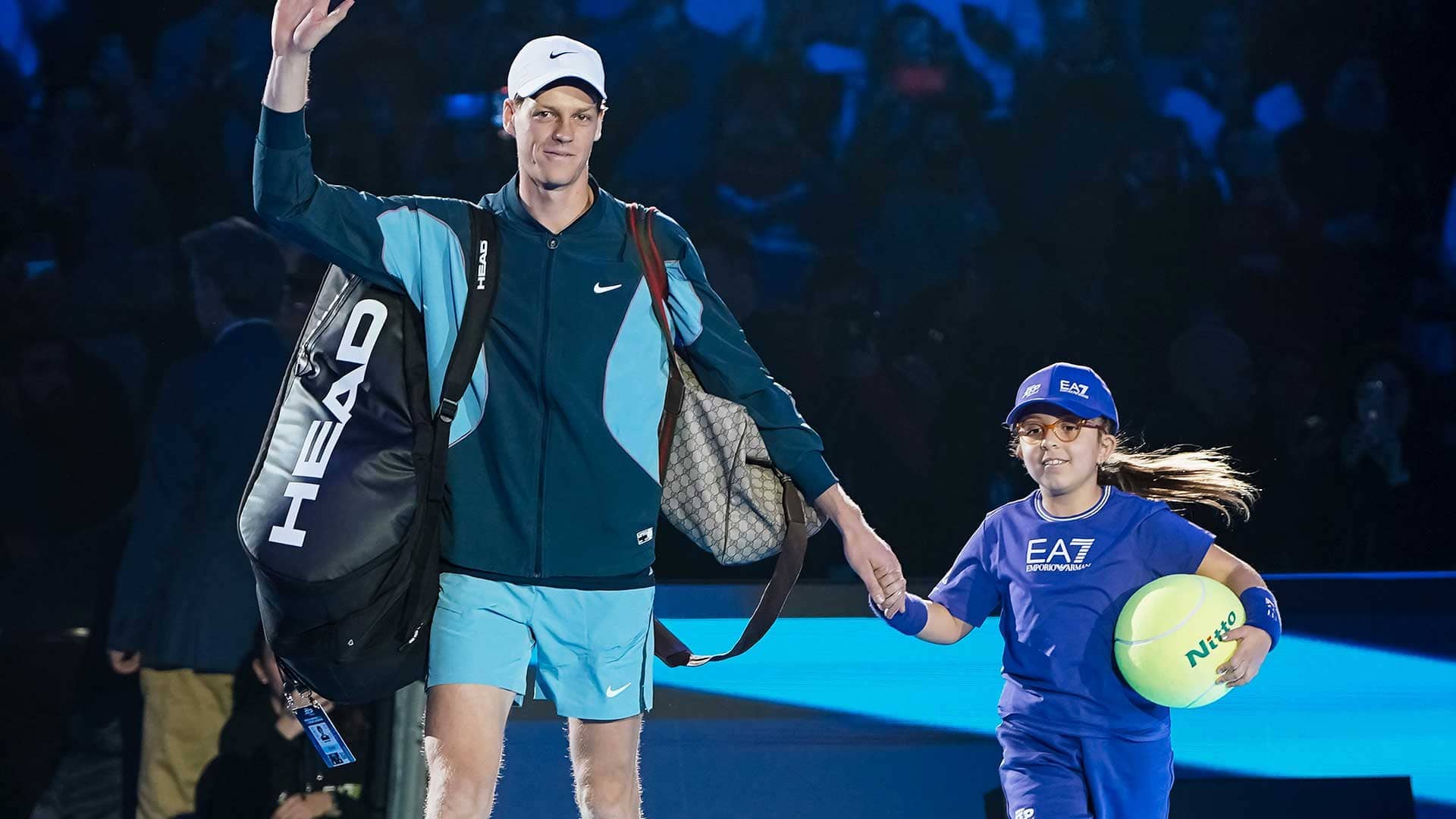 Jannik Sinner walks onto court with mascot Francesca at the Nitto ATP Finals.