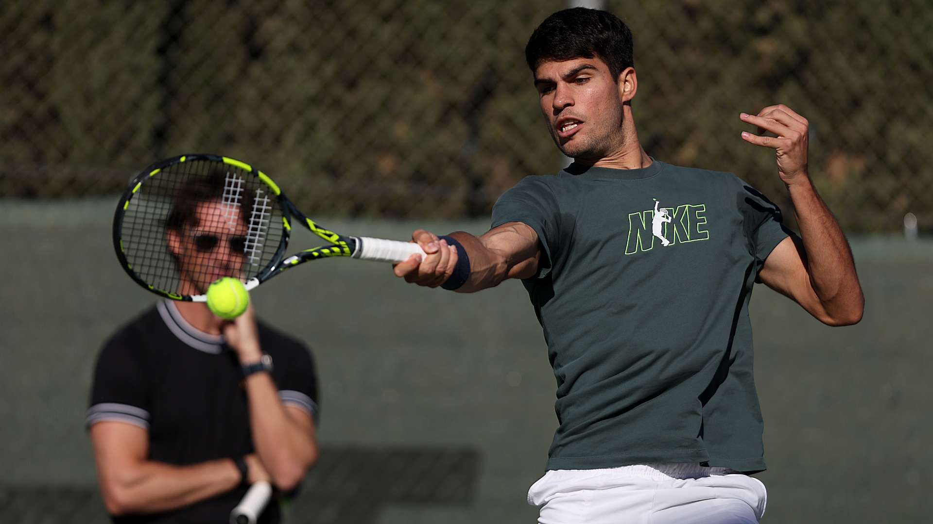 Alcaraz practises a forehand watched by Ferrero during their training session.