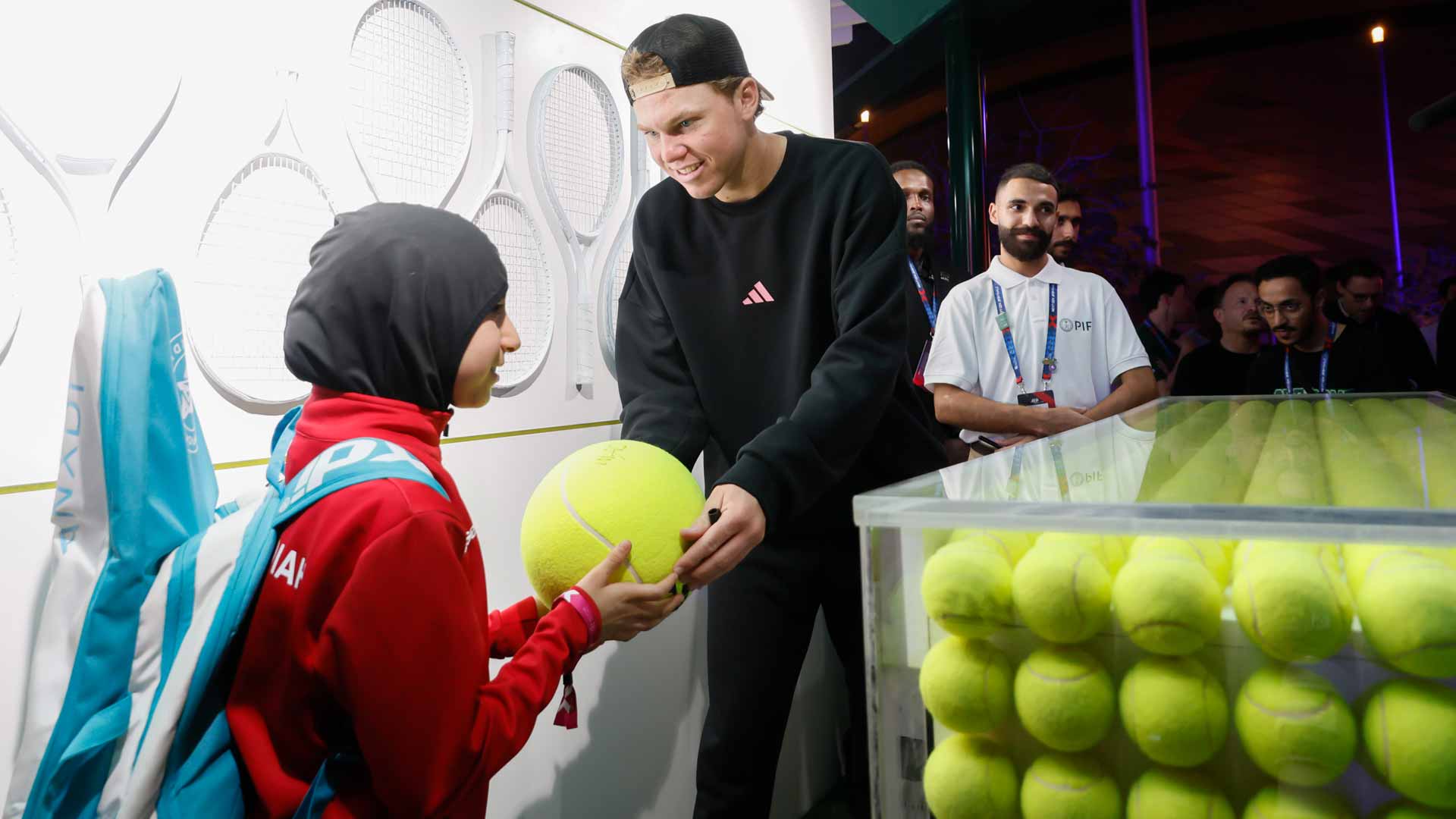 Alex Michelsen signs a ball for a young fan on Thursday at the Next Gen ATP Finals presented by PIF.