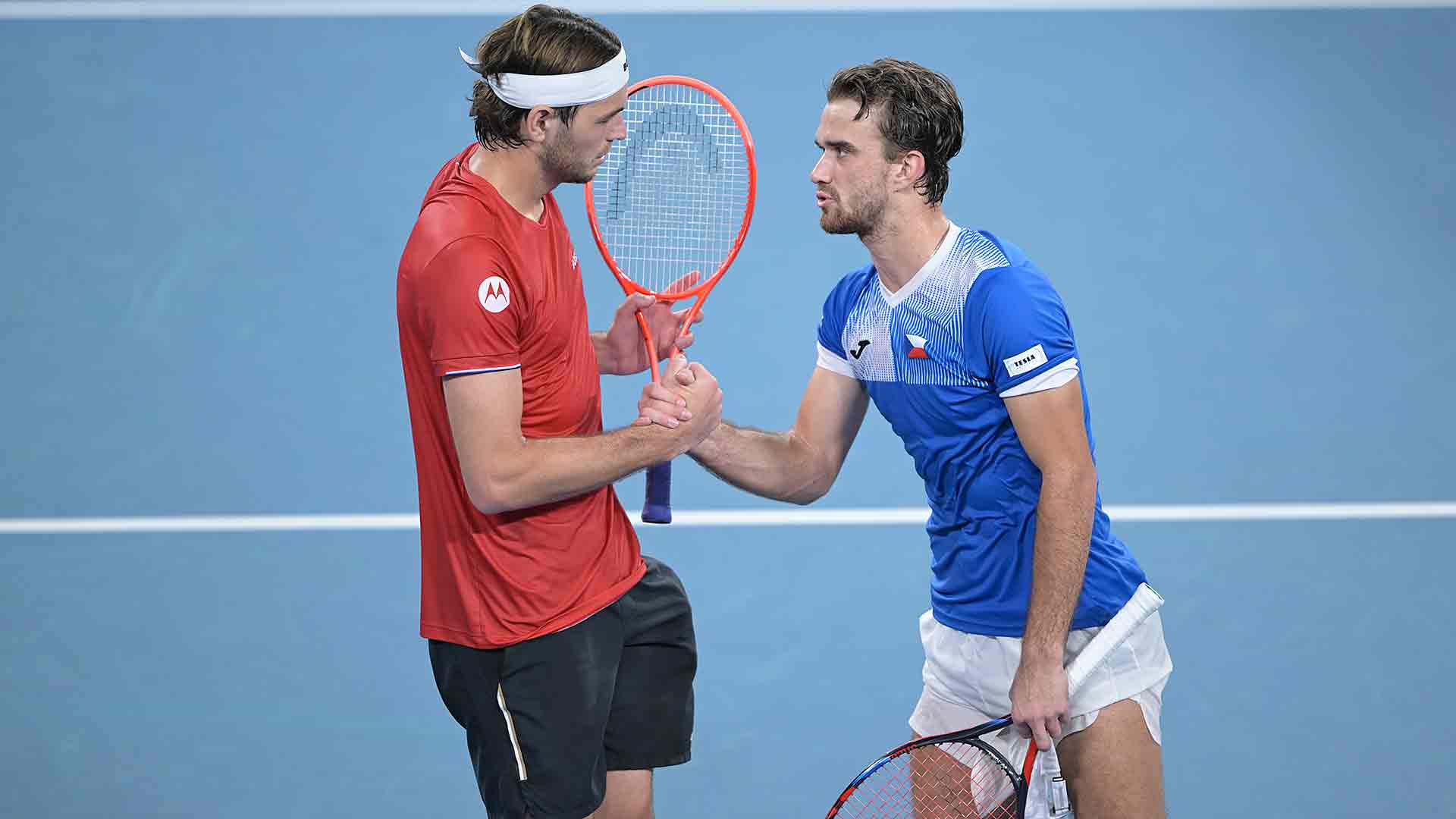 Taylor Fritz y Tomas Machac se saludan en la red, tras la retirada del checo.