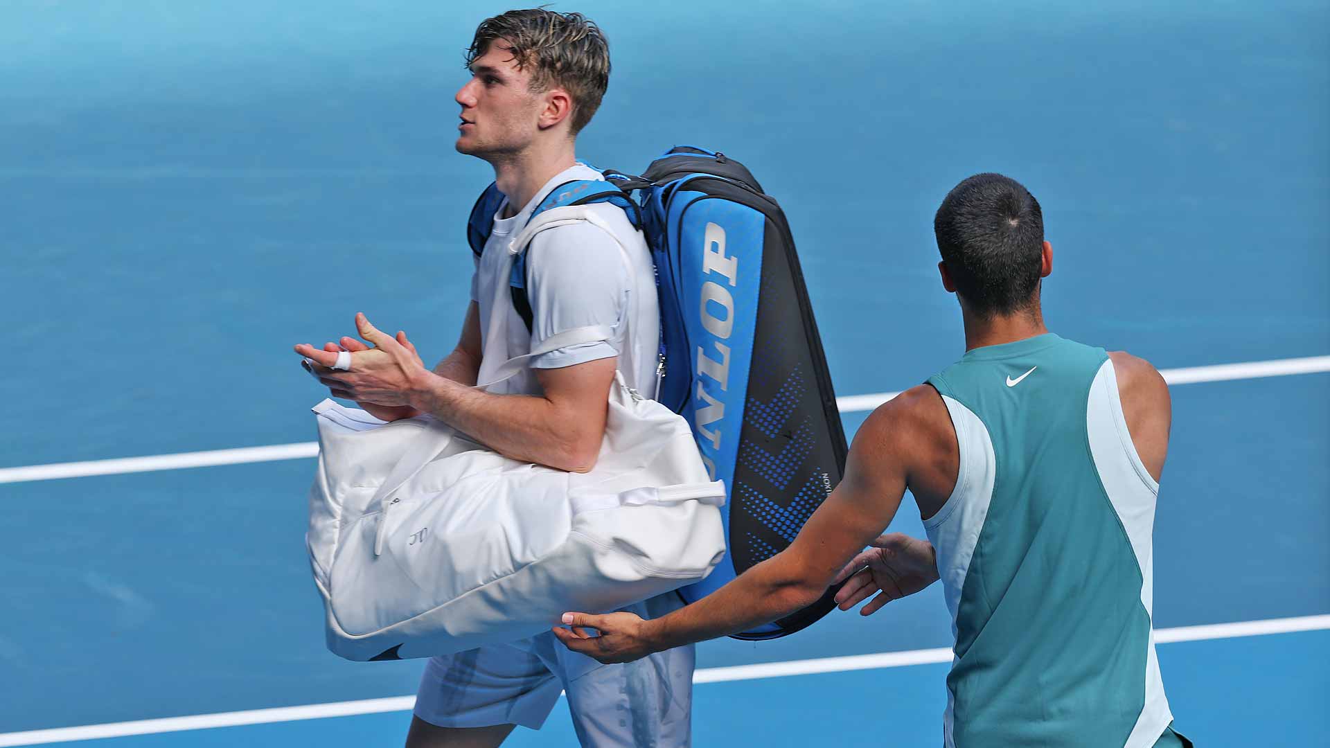 Jack Draper walks off Rod Laver Arena, recognised by his opponent, Carlos Alcaraz.