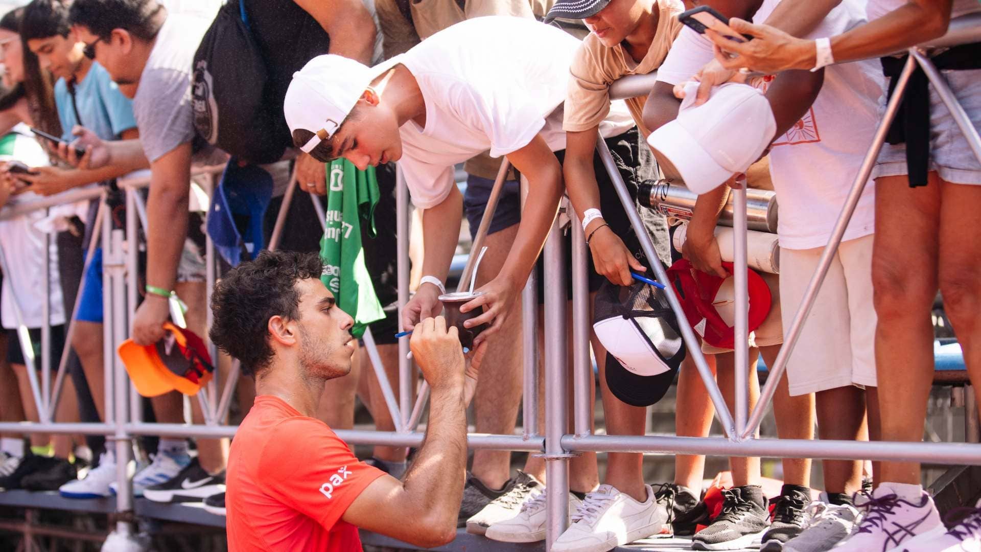 Francisco Cerúndolo firma un autógrafo en un mate, tras ganar R1 de dobles en Buenos Aires junto a Etcheverry.