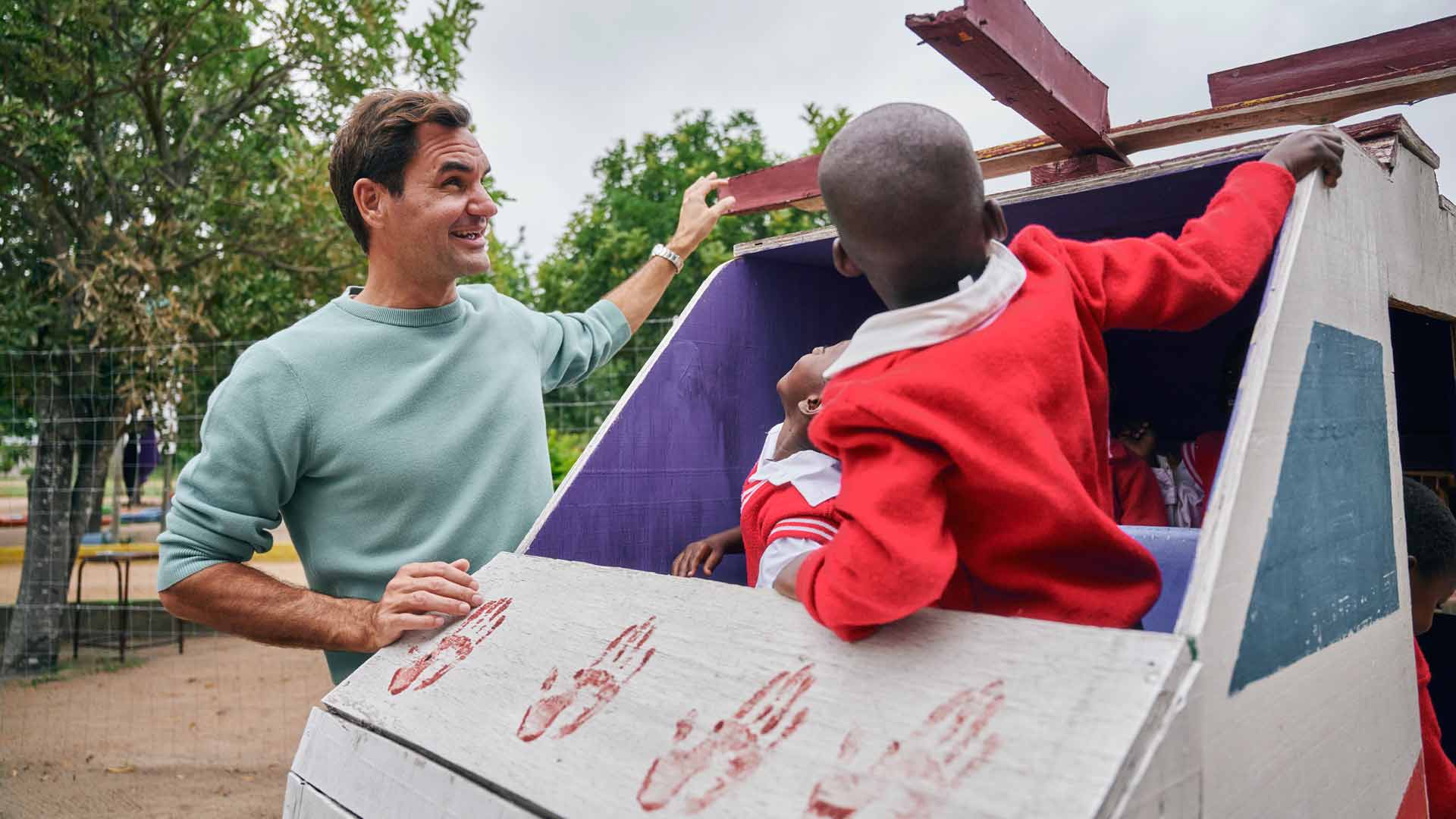 <a href='https://www.atptour.com/en/players/roger-federer/f324/overview'>Roger Federer</a> examines a creative playground element at a primary school in Mpumalanga.
