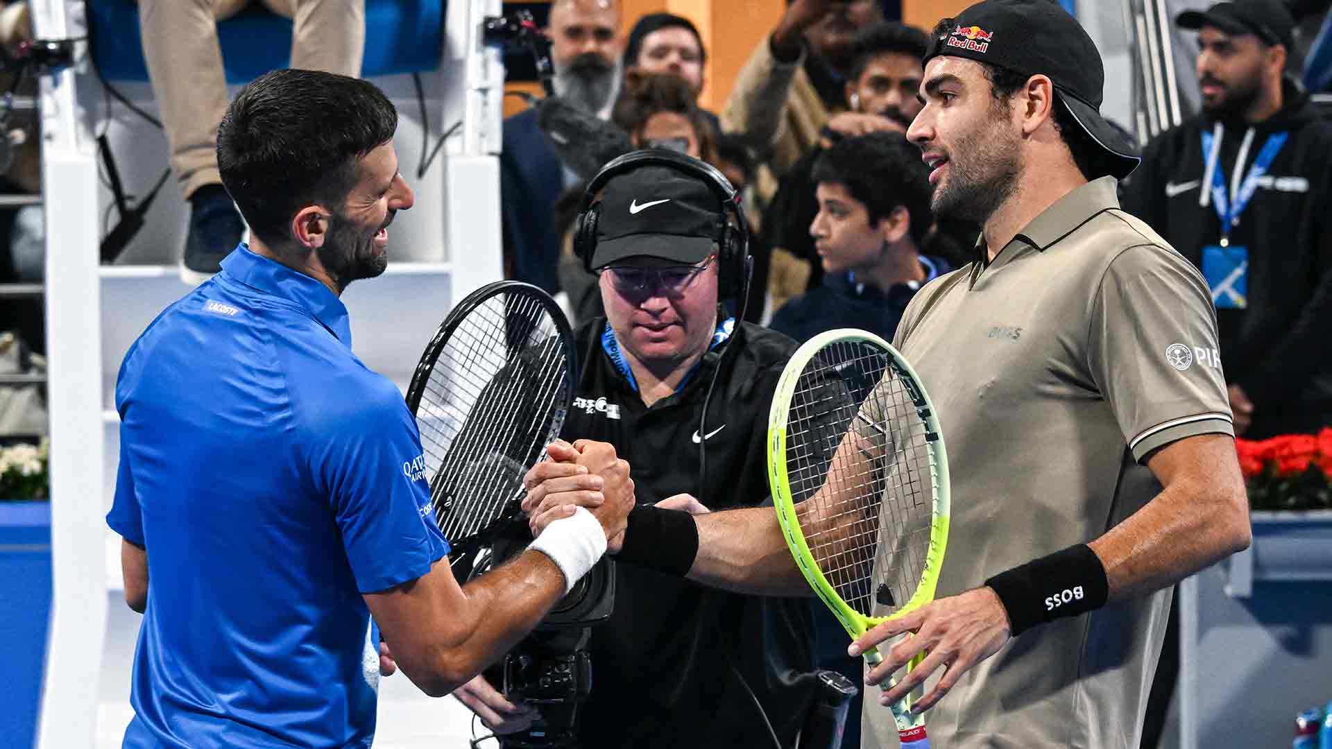 Novak Djokovic y Matteo Berrettini se saludan en la red.