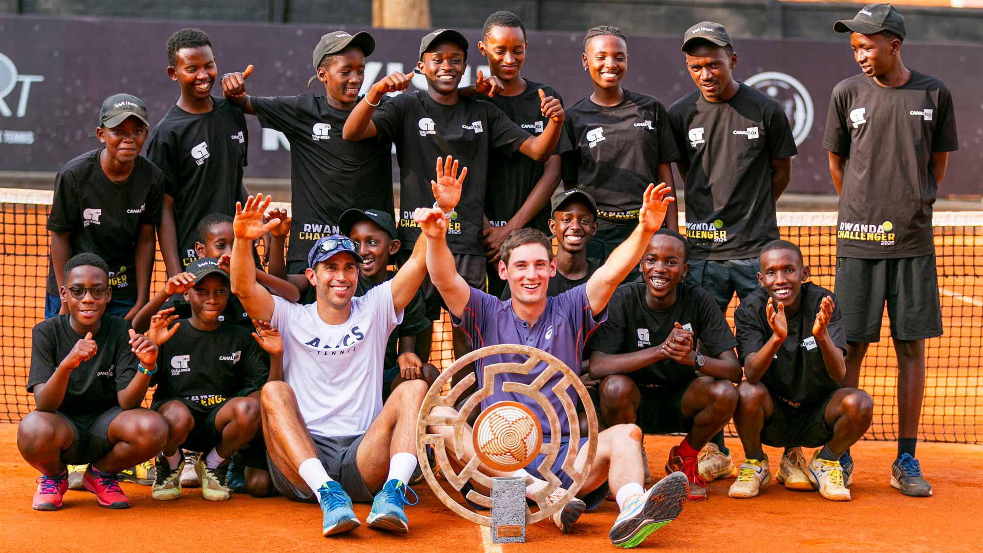 <a href='https://www.atptour.com/en/players/valentin-royer/r0eb/overview'>Valentin Royer</a> celebrates his triumph with the Kigali ballkids.