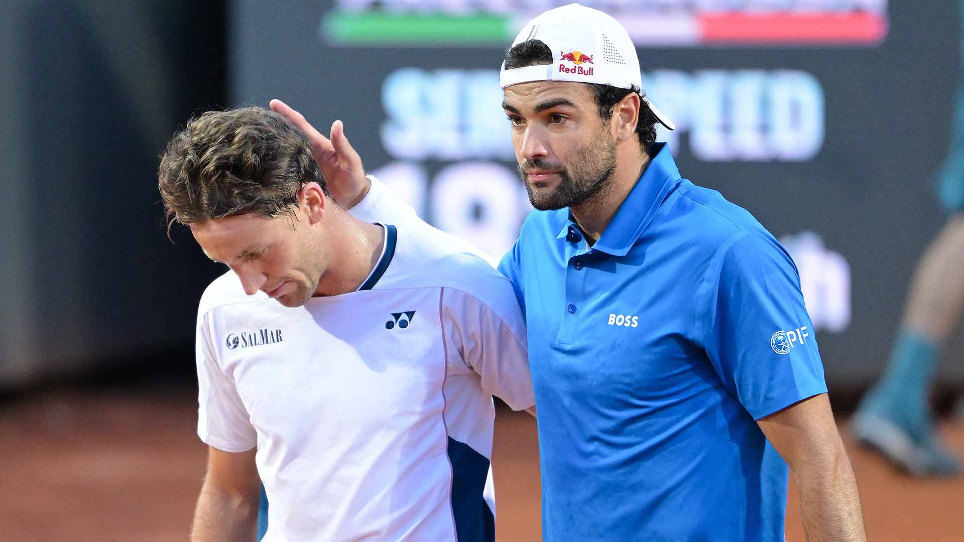 Casper Ruud consoles Matteo Berrettini after his decision to retire from their third-round match in Rome Monday.
