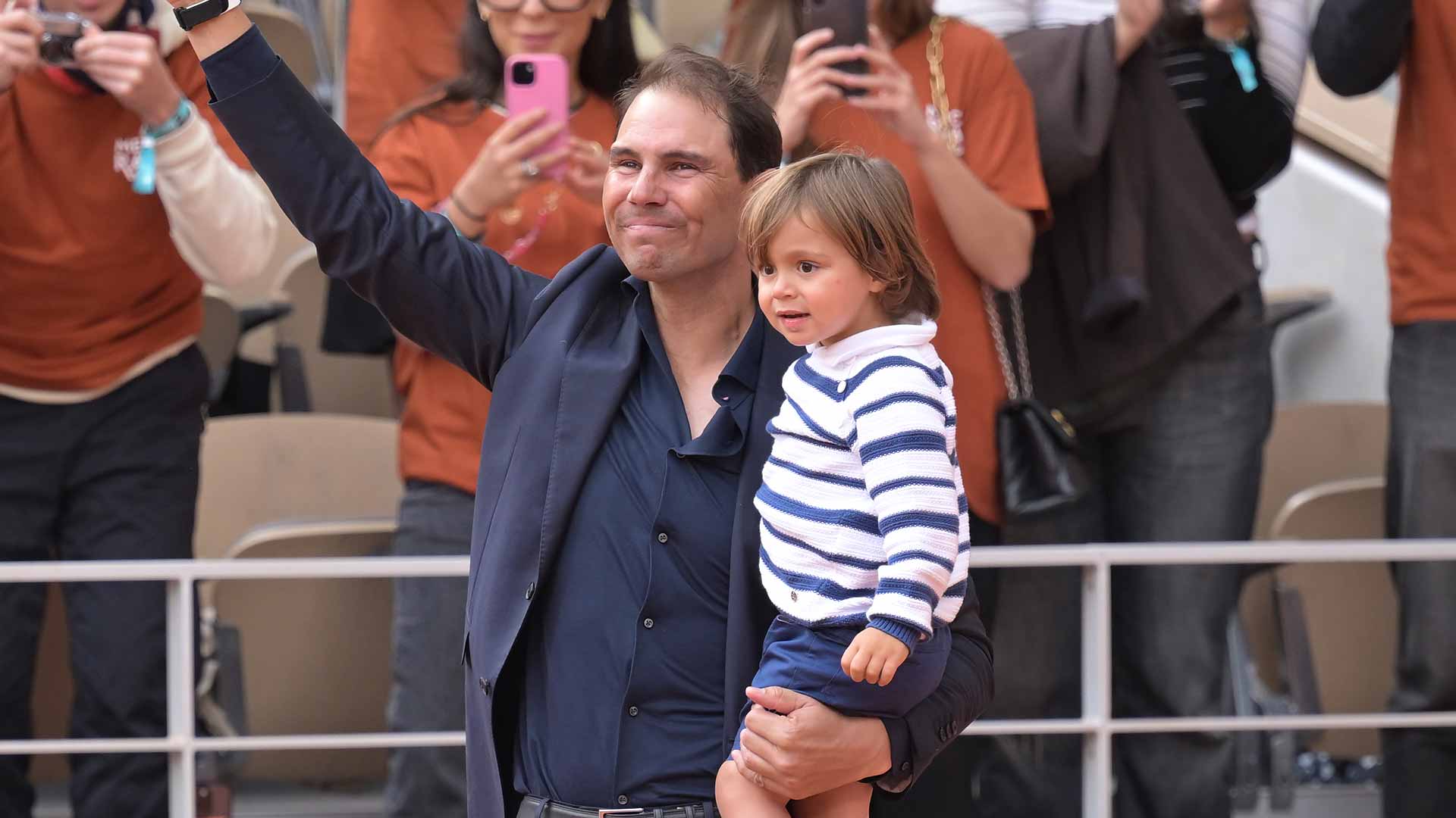 Rafael Nadal shares a special moment with his son as he waves to the crowd inside Court Philippe-Chatrier on Sunday.