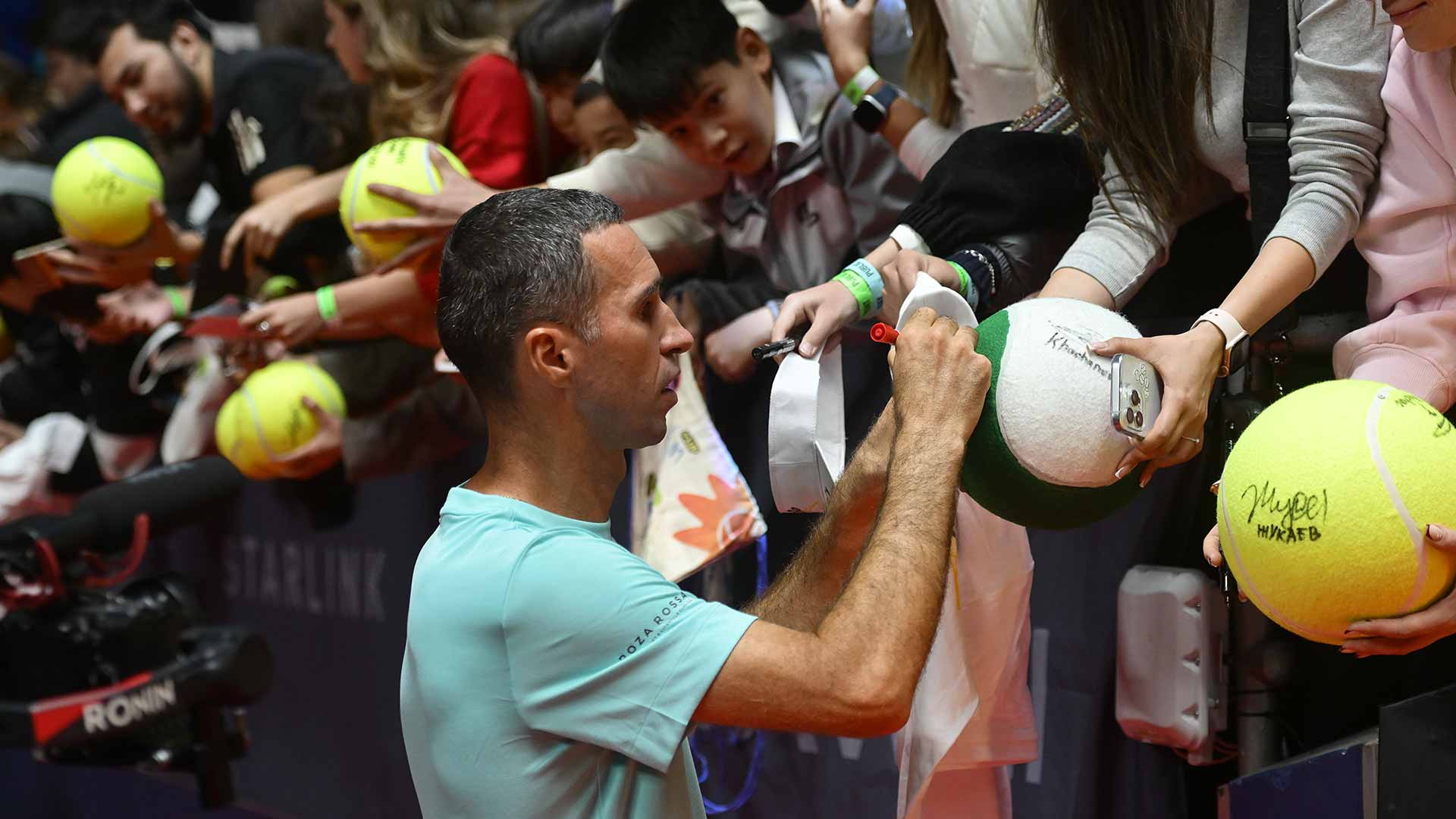 <a href='https://www.atptour.com/en/players/mikhail-kukushkin/k926/overview'>Mikhail Kukushkin</a> signs autographs for fans in Almaty on Wednesday
