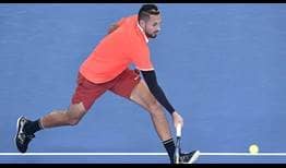 Nick Kyrgios defeats Ryan Harrison in three sets to reach the second round at the Brisbane International on Tuesday.