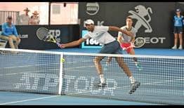 Rajeev Ram poaches at the net for a forehand volley in Brisbane on Thursday as Joe Salisbury watches on.
