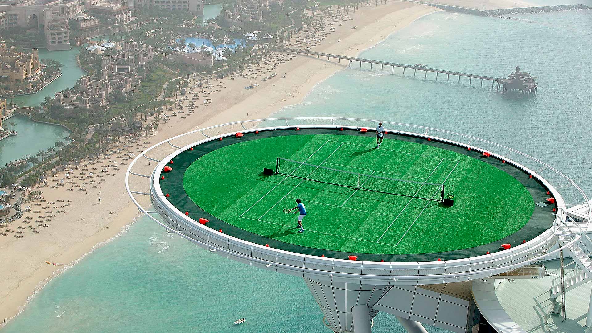 Roger Federer y Andre Agassi tienen un 'golpe' amistoso en el helipuerto del Burj Al Arab antes del Campeonato de hombres libre de impuestos de Dubái 2005.