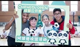 Felix Auger-Aliassime and Hyeon Chung pose with a photo with students from Jinhui Primary School on Monday in Chengdu.
