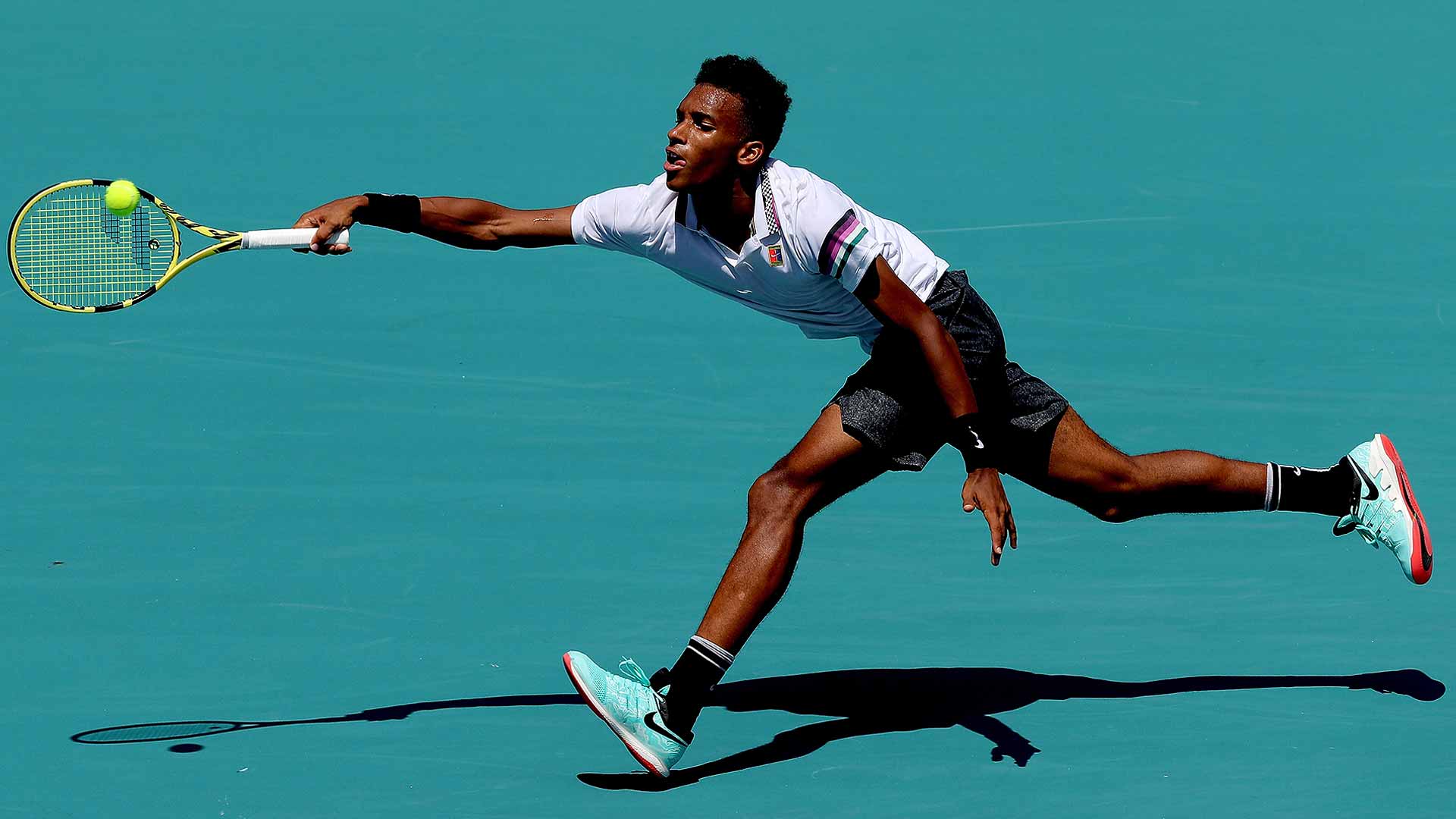 Miami 2019. <a href='https://www.atptour.com/en/players/felix-auger-aliassime/ag37/overview'>Felix Auger-Aliassime</a> stretches for a ball while playing <a href='https://www.atptour.com/en/players/nikoloz-basilashvili/bg23/overview'>Nikoloz Basilashvili</a> in Masters 1000 action. (Photo by Matthew Stockman/Getty Images)
