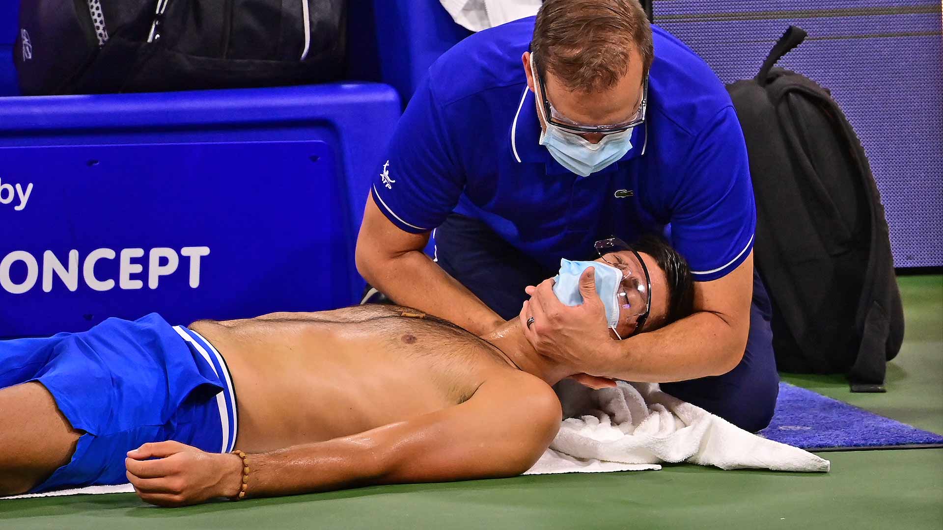 <a href='https://www.atptour.com/en/players/novak-djokovic/d643/overview'>Novak Djokovic</a> receives a neck adjustment after the first set.
