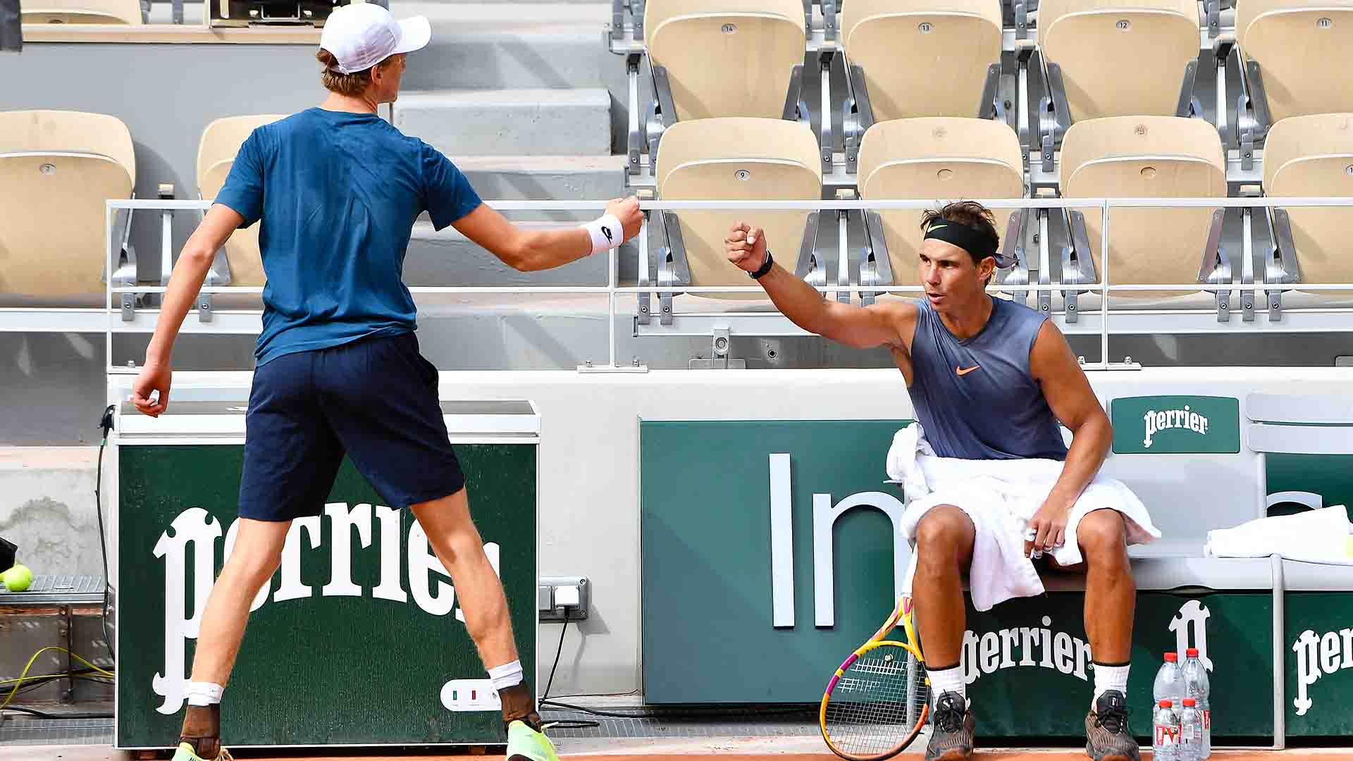 <a href='https://www.atptour.com/en/players/jannik-sinner/s0ag/overview'>Jannik Sinner</a> and <a href='https://www.atptour.com/en/players/rafael-nadal/n409/overview'>Rafael Nadal</a> bump fists during a practice session at <a href='https://www.atptour.com/en/tournaments/roland-garros/520/overview'>Roland Garros</a>.
