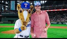 John Isner, who helped launch the Dallas Open earlier in the day, throws out the first pitch at the Texas Rangers-New York Yankees game