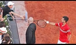 Novak Djokovic gives a young fan his racquet after clinching the Roland Garros title on Sunday.