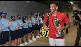 Felix Auger-Aliassime holds the ATP Cup trophy.