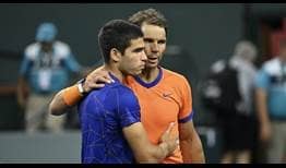 Carlos Alcaraz y Rafael Nadal se abrazan en la red tras disputar las semifinales del BNP Paribas Open.