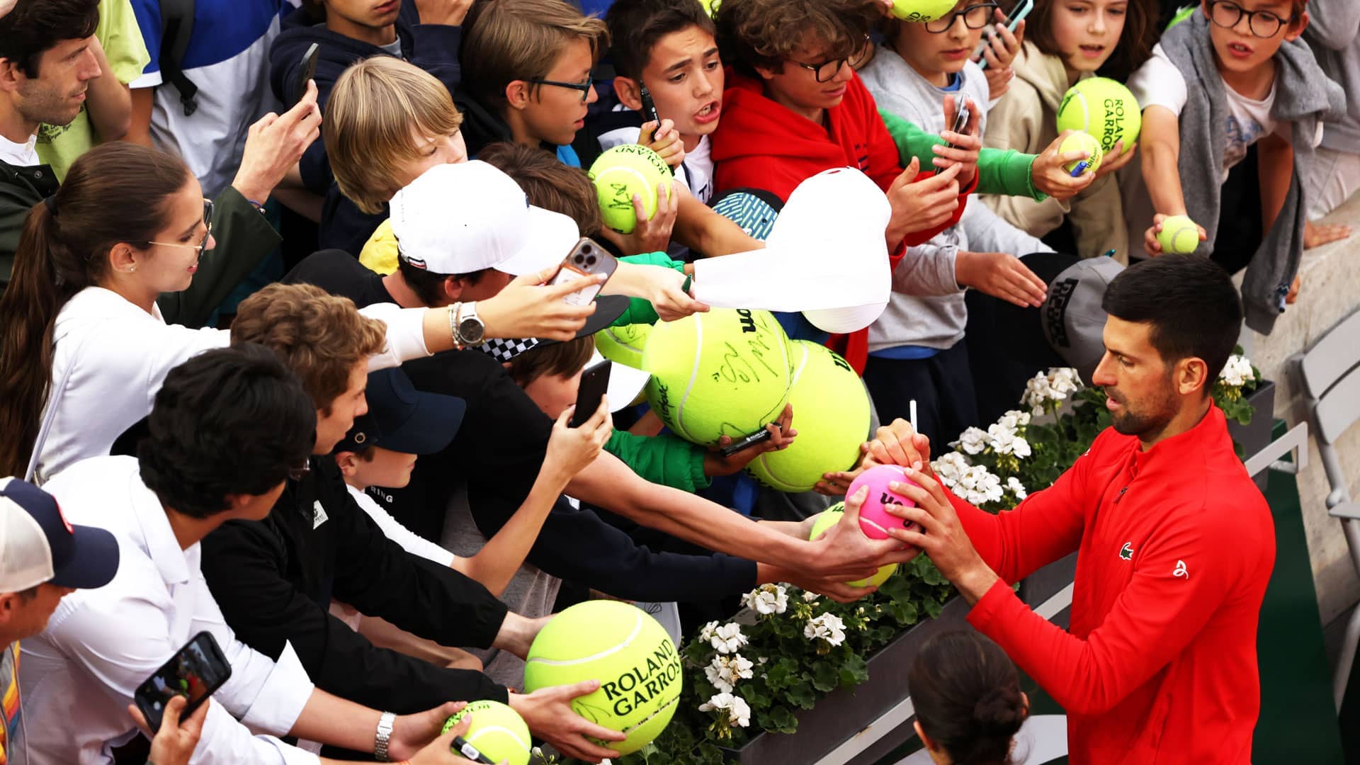 <a href='https://www.atptour.com/en/players/novak-djokovic/d643/overview'>Novak Djokovic</a> signs autographs after his second-round win at <a href='https://www.atptour.com/en/tournaments/roland-garros/520/overview'>Roland Garros</a>.