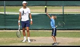 Novak Djokovic spends time with his son, Stefan, on the practice court during Wimbledon.