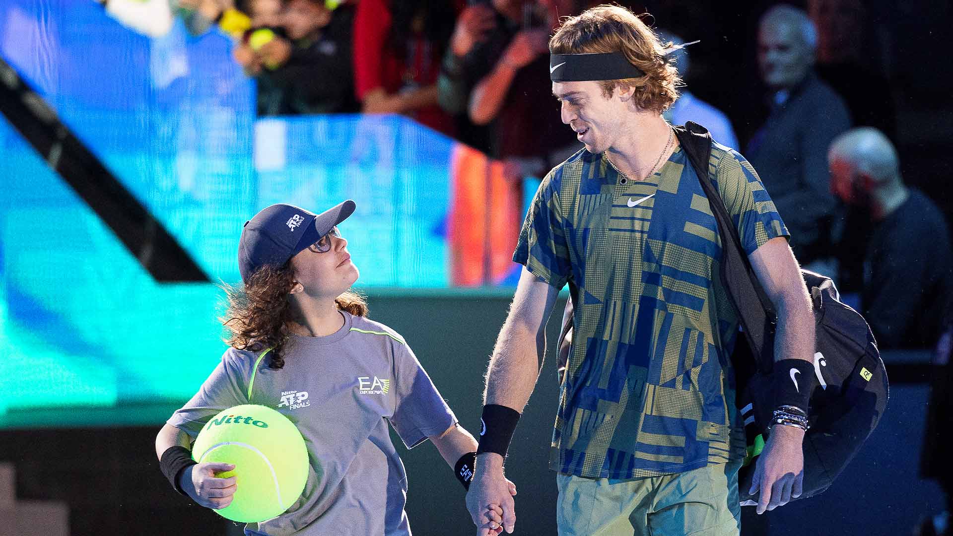 Andrey Rublev walks out to centre court with Nicole De Angelis at the Nitto ATP Finals.