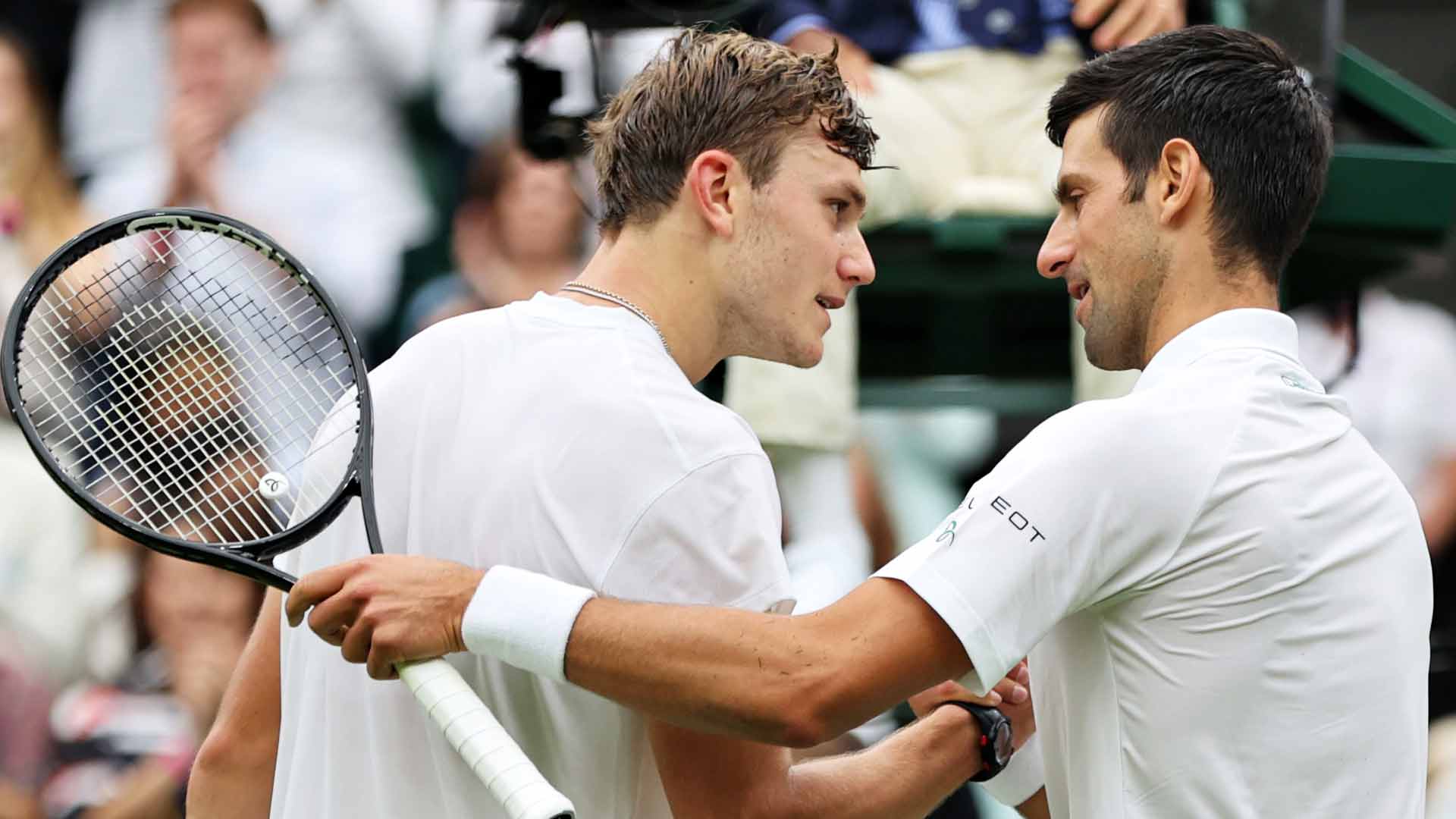 Draper and Djokovic embrace at the net following their clash at <a href='https://www.atptour.com/en/tournaments/wimbledon/540/overview'>Wimbledon</a> in 2021.