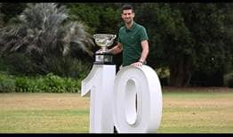 Novak Djokovic poses with the Norman Brookes Challenge Cup on Monday in the gardens of Melbourne's Government House.