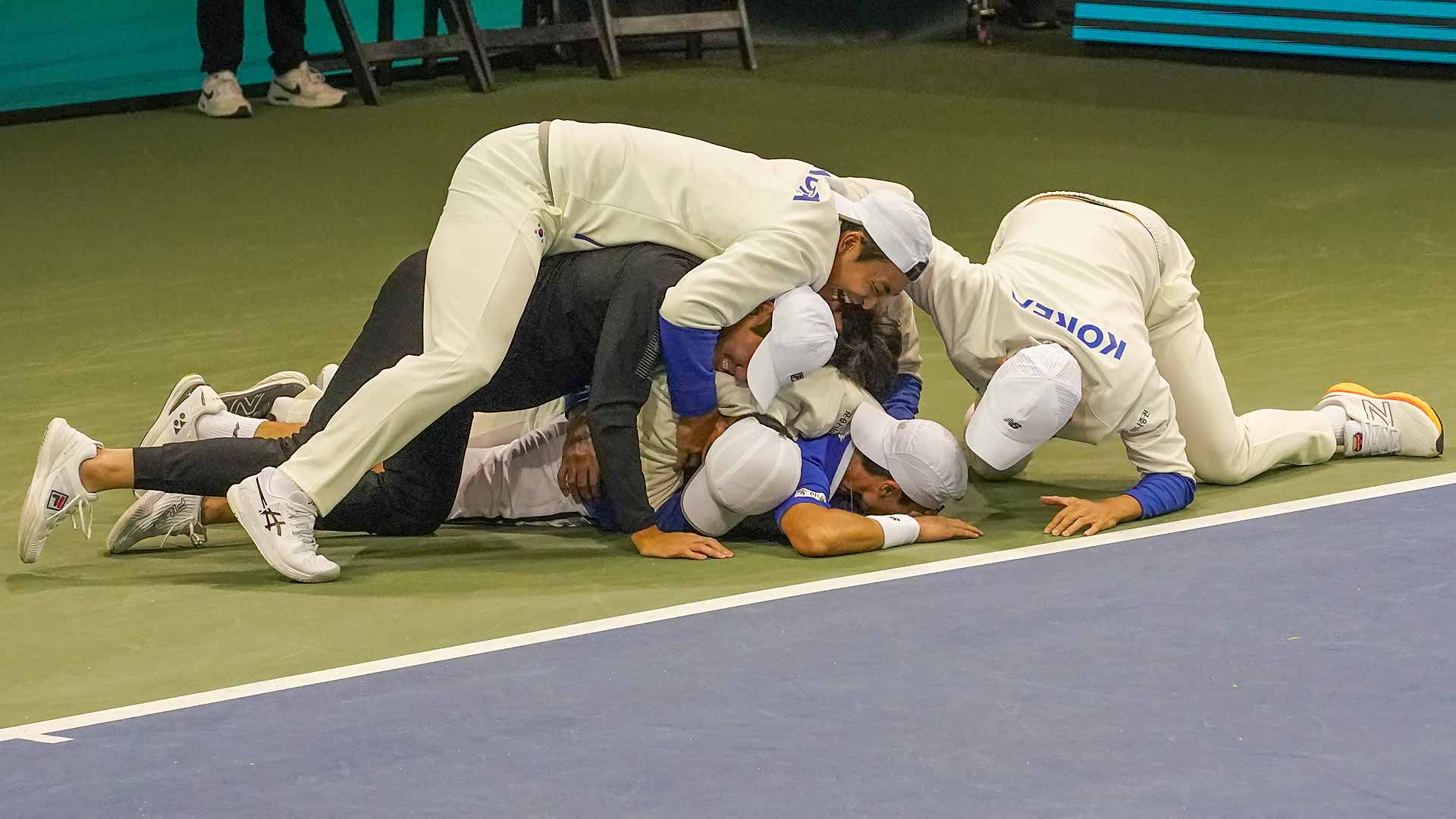 Seong-chan Hong is mobbed by his South Korea teammates after their remarkable Davis Cup comeback on Sunday in Seoul.
