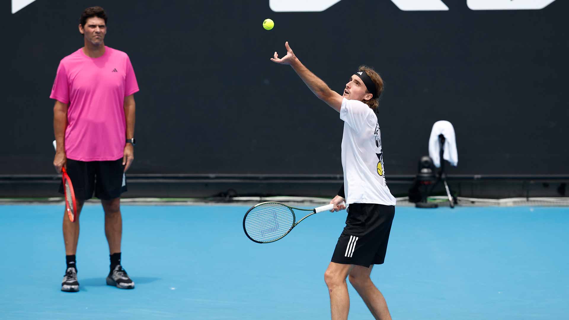 Stefanos Tsitsipas practises at the 2023 Australian Open while Coach Mark Philippoussis watches on.