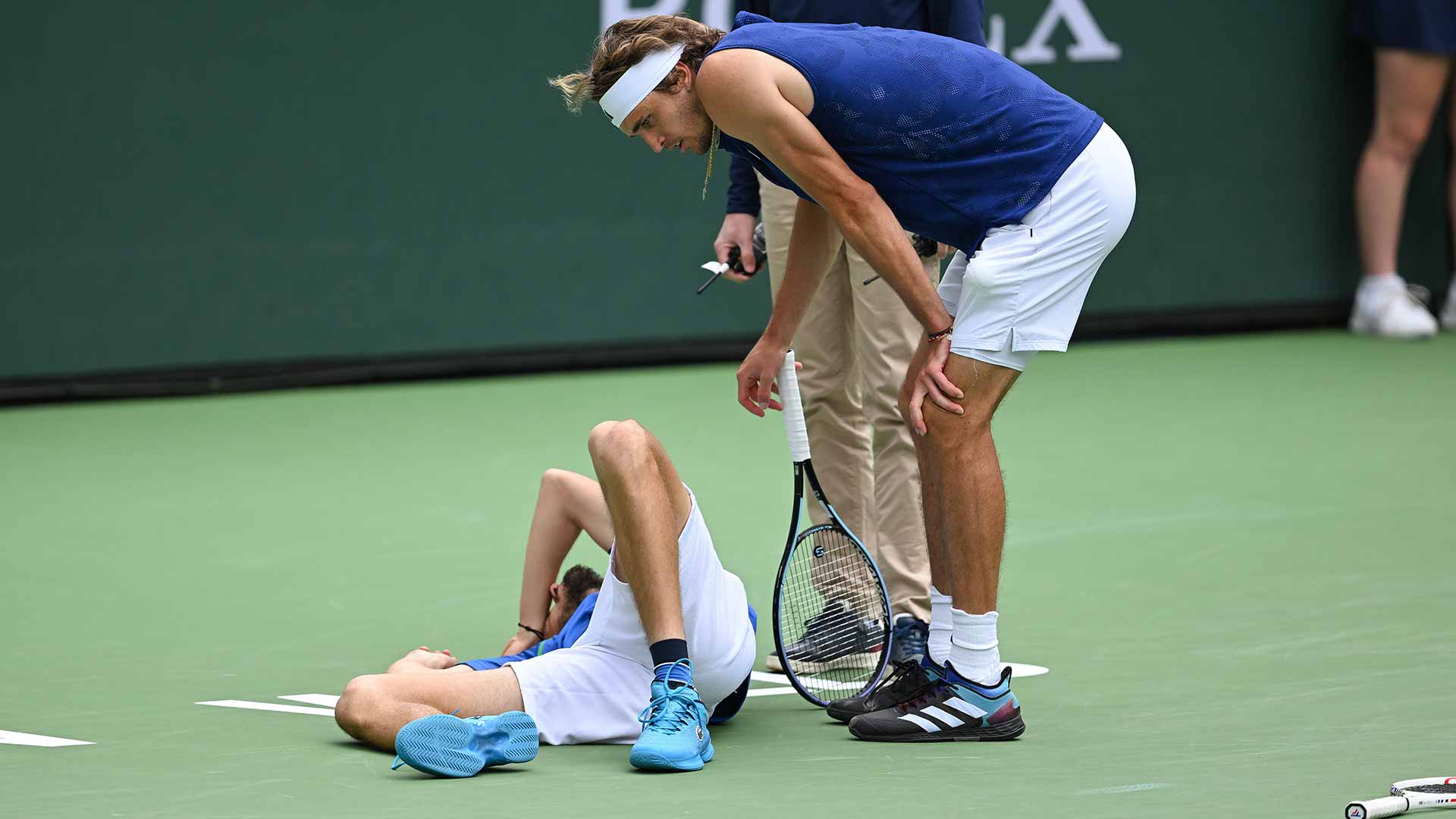 <a href='https://www.atptour.com/en/players/daniil-medvedev/mm58/overview'>Daniil Medvedev</a> takes time out after an ankle injury as <a href='https://www.atptour.com/en/players/alexander-zverev/z355/overview'>Alexander Zverev</a> looks on.