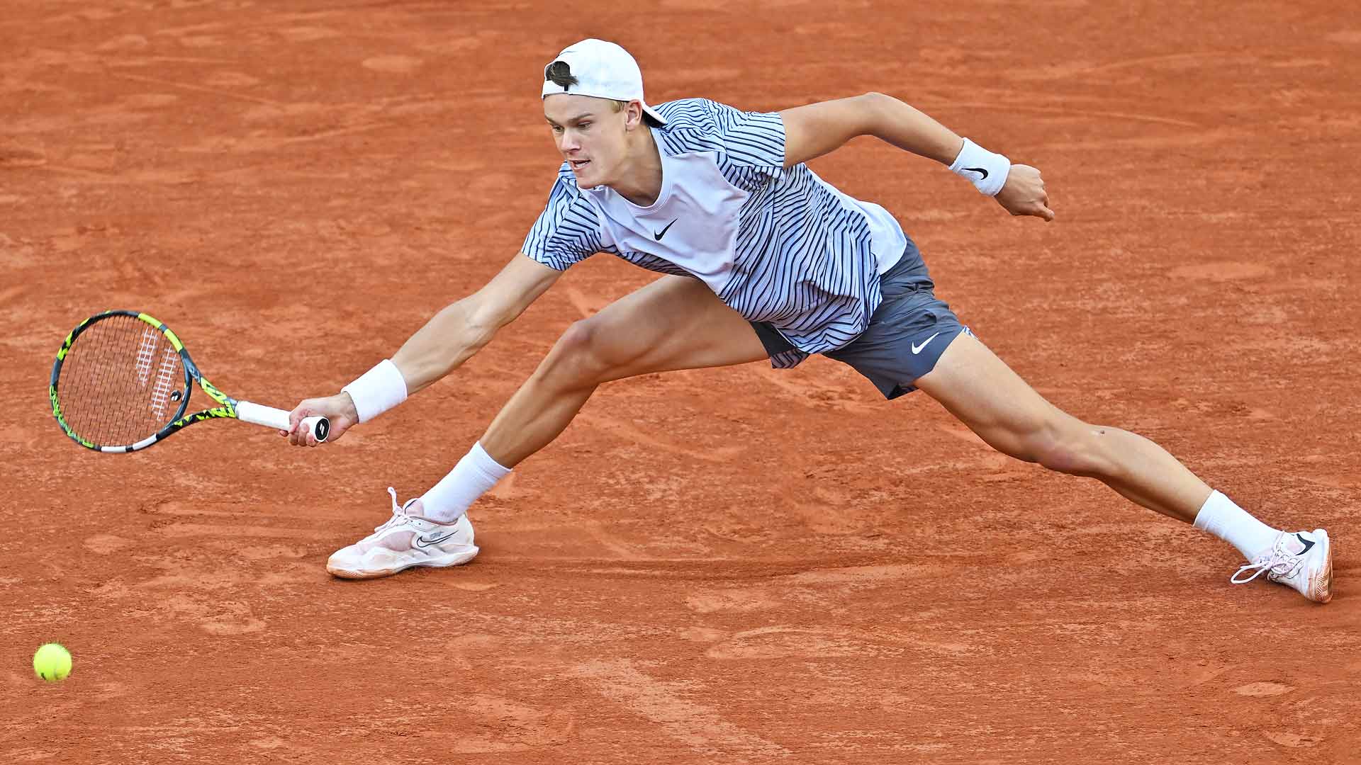 Holger Rune slides for a ball en route to victory against Francisco Cerundolo on Monday at Roland Garros.