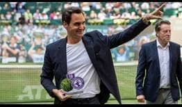 El 10 veces campeón Roger Federer recibe un premio del director del torneo, Ralf Weber, durante la jornada del miércoles en Halle.