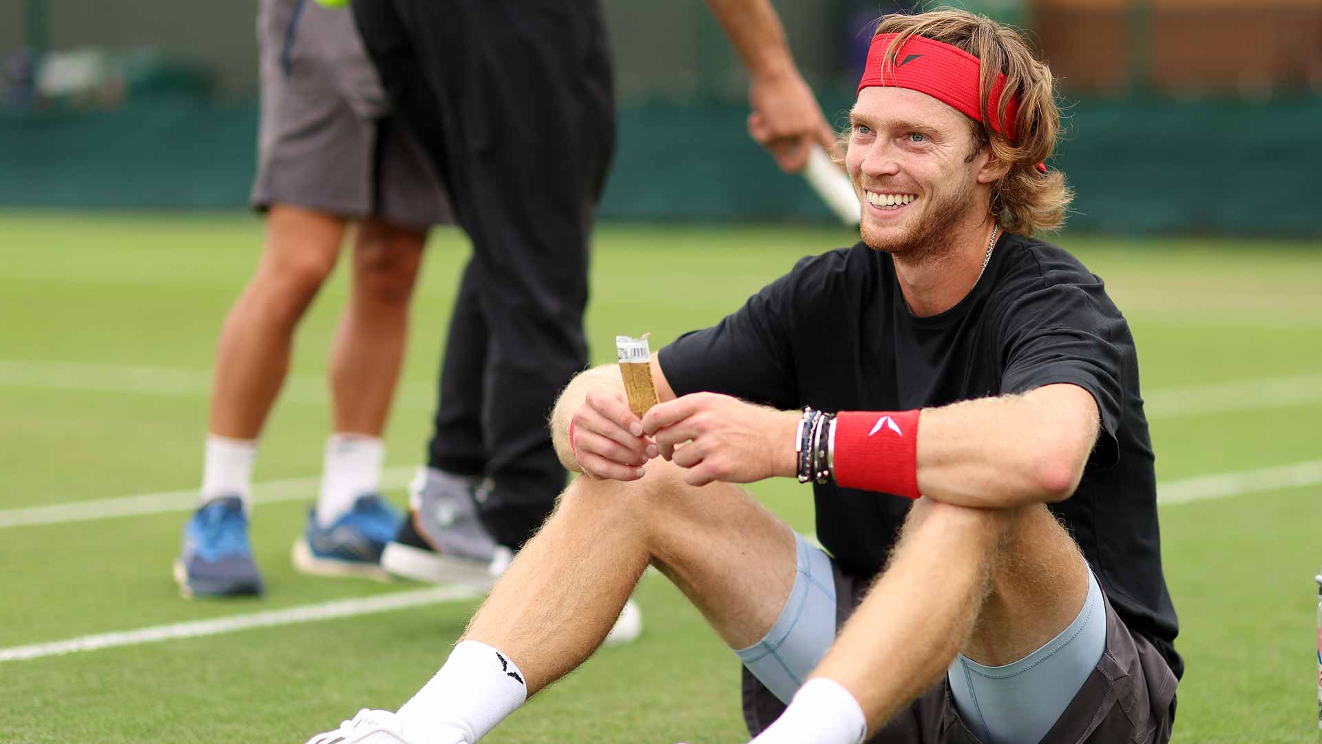 <a href='https://www.atptour.com/en/players/andrey-rublev/re44/overview'>Andrey Rublev</a> enjoys a break during practice on Tuesday at <a href='https://www.atptour.com/en/tournaments/wimbledon/540/overview'>Wimbledon</a>.