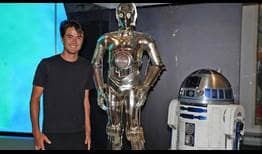Taro Daniel poses with C-3PO and R2-D2 from Star Wars at the National Museum of American History.