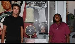 Taro Daniel and Hailey Baptiste pose with Billie Jean King's kit from the 1973 Battle of the Sexes match at the National Museum of American History.