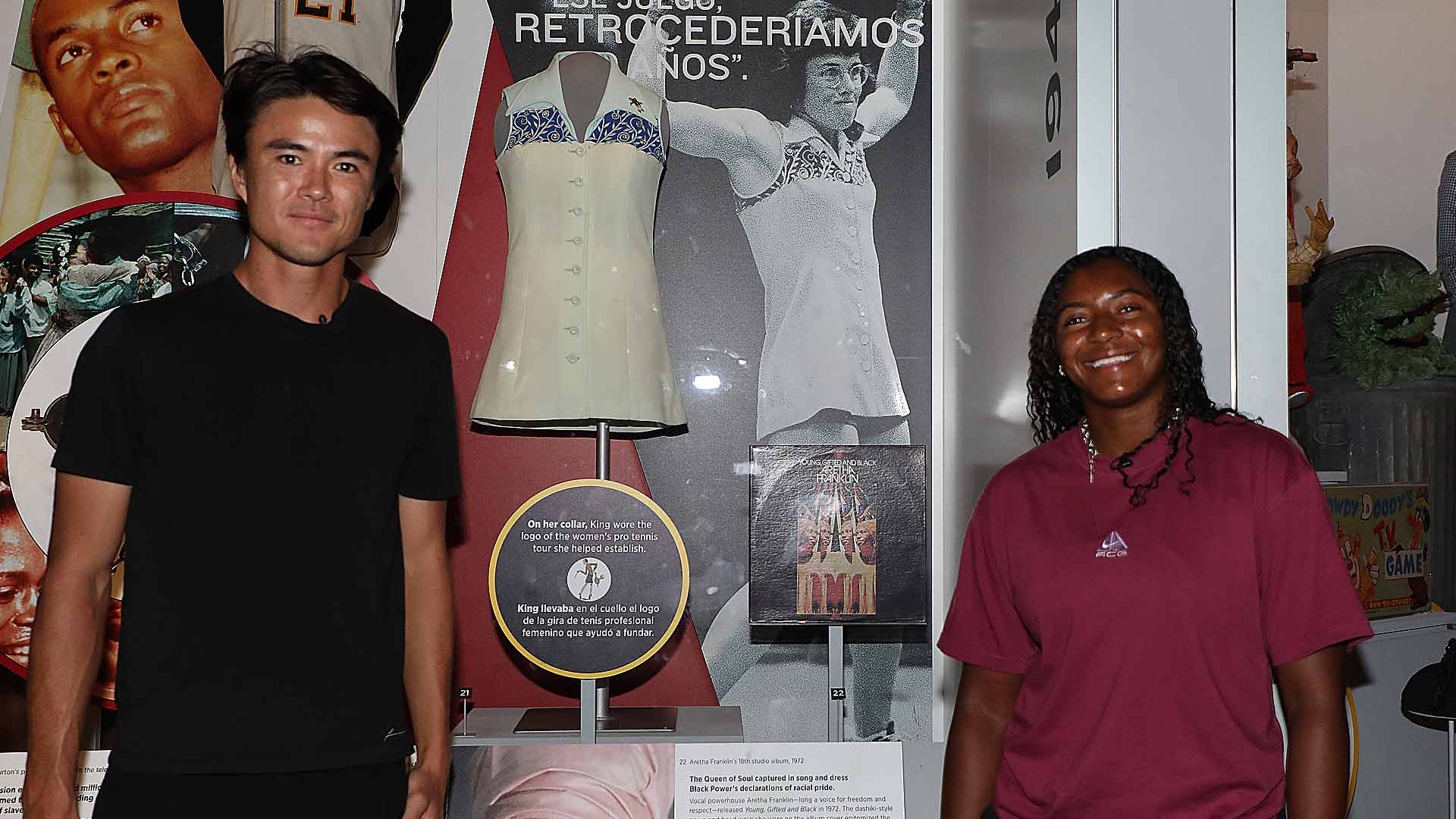<a href='https://www.atptour.com/en/players/taro-daniel/da81/overview'>Taro Daniel</a> and Hailey Baptiste pose with Billie Jean King's kit from the 1973 Battle of the Sexes match at the National Museum of American History.