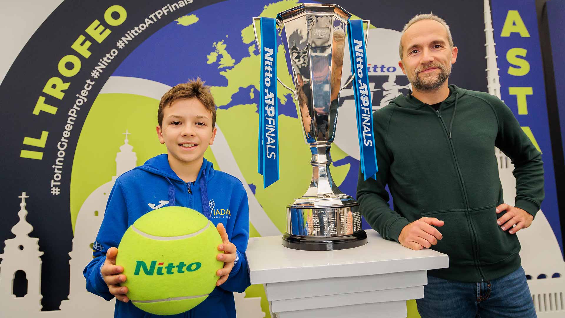 Los aficionados posan con la réplica del trofeo de las Nitto ATP Finals en el Fan Village del Pala Alpitour.