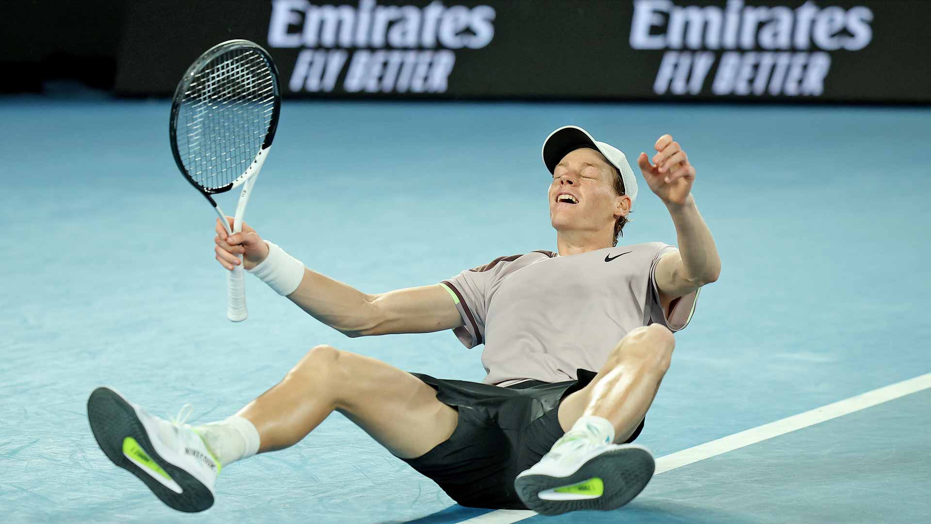 Jannik Sinner falls to the court after beating Daniil Medvedev for his maiden Grand Slam crown at the Australian Open.