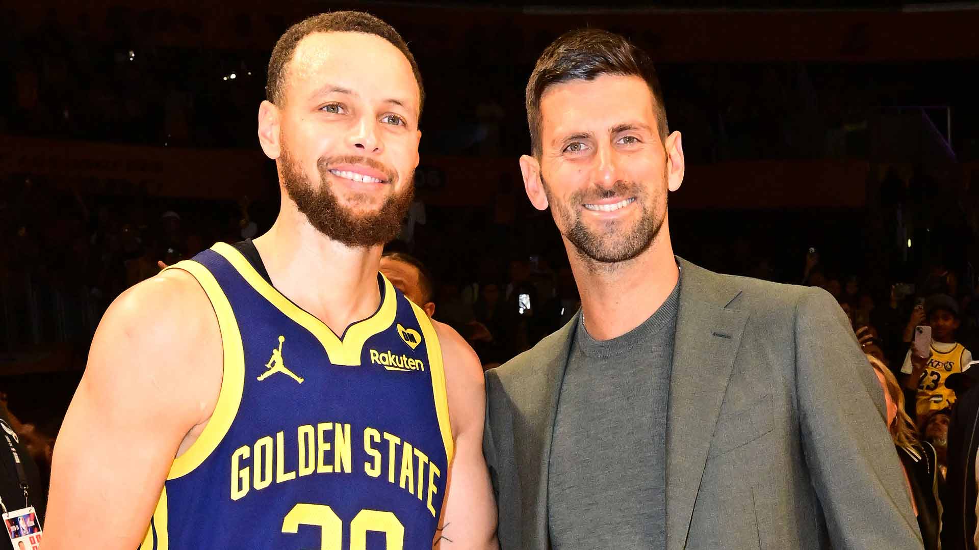 Stephen Curry and Novak Djokovic pose for a photo after the Golden State Warriors' win Saturday.