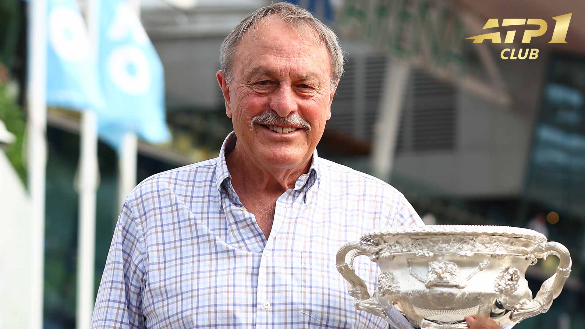 John Newcombe poses with the Australian Open trophy on Sunday at Melbourne Park.