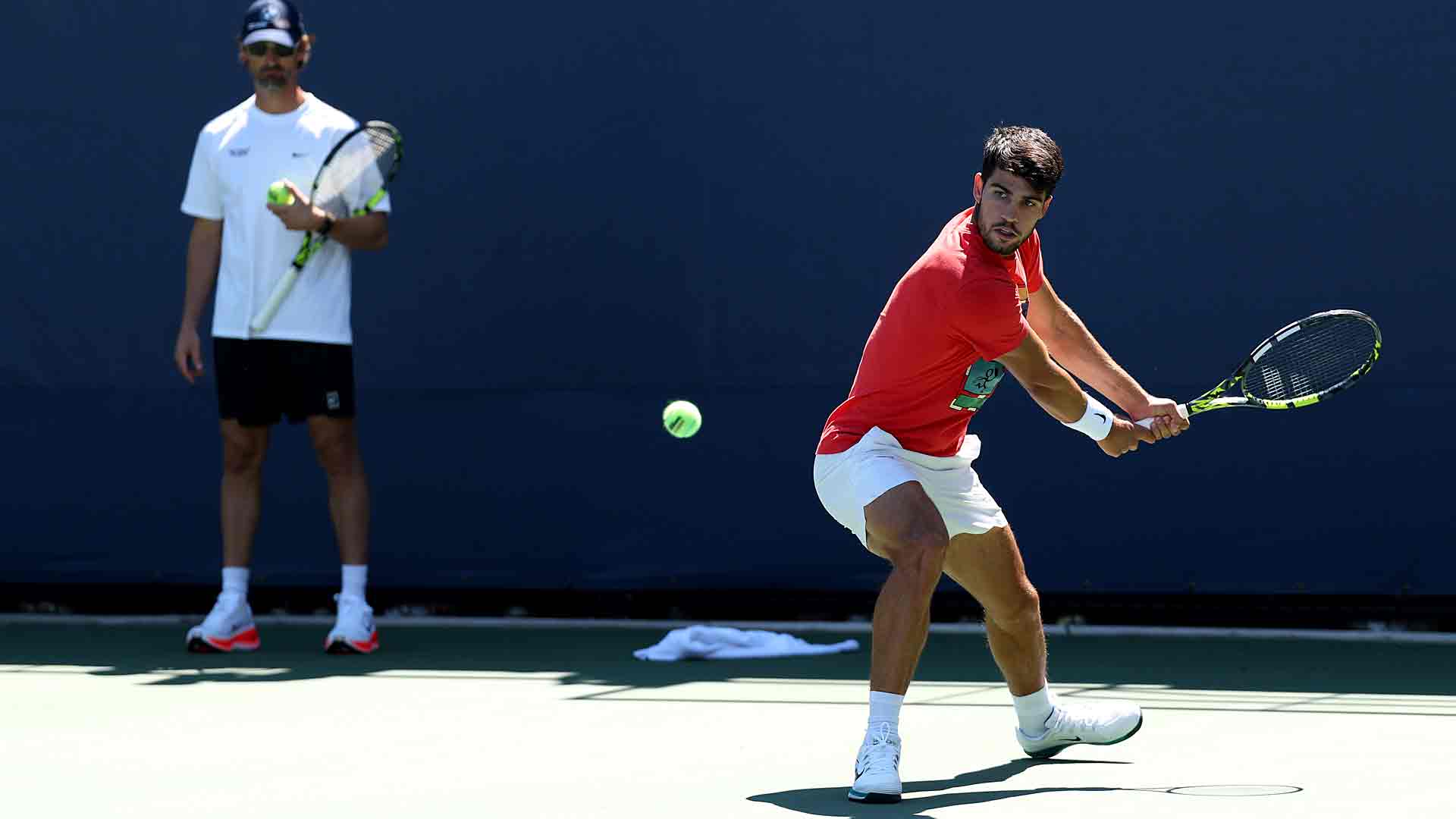 Carlos Alcaraz, bajo la atenta mirada de Juan Carlos Ferrero, durante un entrenamiento en el US Open 2025.